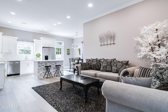 202 Saint Matthias Dr, Carencro, LA 70520 - living area with light wood-style flooring, recessed lighting, crown molding, and a chandelier