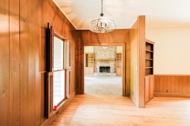 1867 N Old 179, Whigham, GA 39897 - hallway with light wood finished floors, a chandelier, wooden walls, healthy amount of natural light, and built in shelves