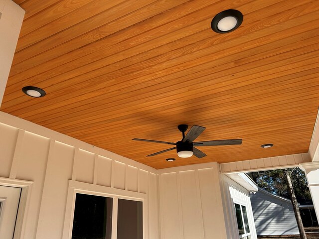 living room with a tray ceiling, crown molding, ceiling fan, and dark wood-type flooring