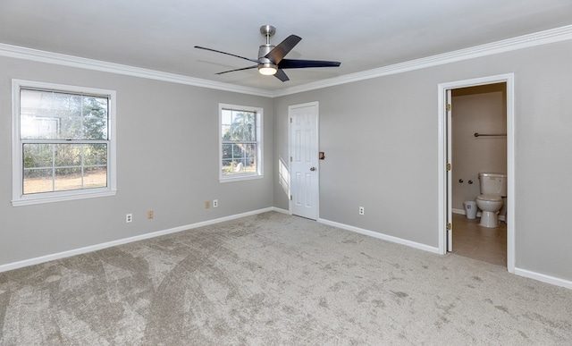 unfurnished bedroom with ceiling fan, crown molding, ensuite bathroom, and light carpet