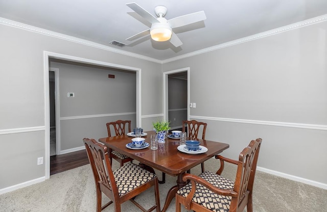 dining room with ceiling fan, carpet, and ornamental molding