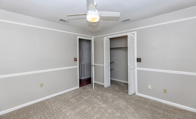 unfurnished bedroom featuring ceiling fan, light colored carpet, and a closet