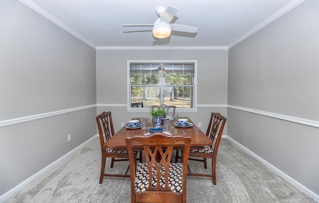 carpeted dining space featuring ceiling fan and crown molding