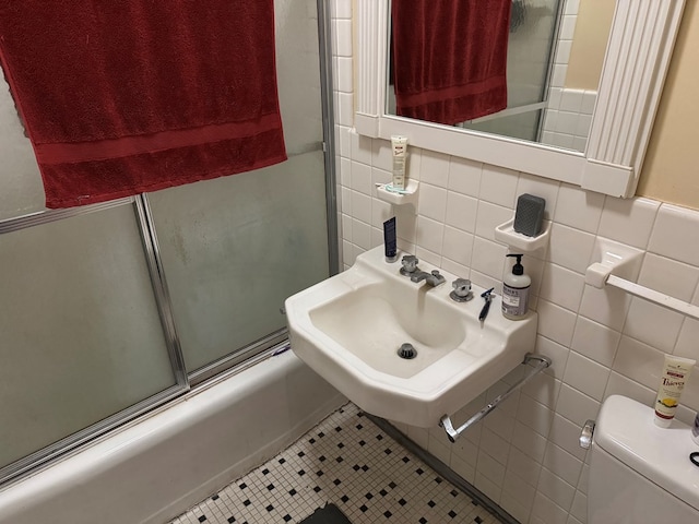 1420 Parallel Dr NW, Cairo, GA 39828 - bathroom with tile walls, tile patterned flooring, shower / bath combination with glass door, and toilet