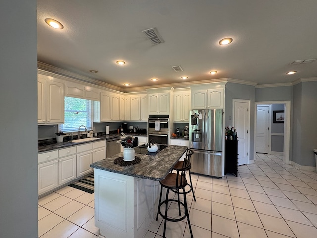 2451 Lake Douglas Rd, Bainbridge, GA 39819 - kitchen featuring stainless steel appliances, visible vents, a sink, crown molding, and a breakfast bar area