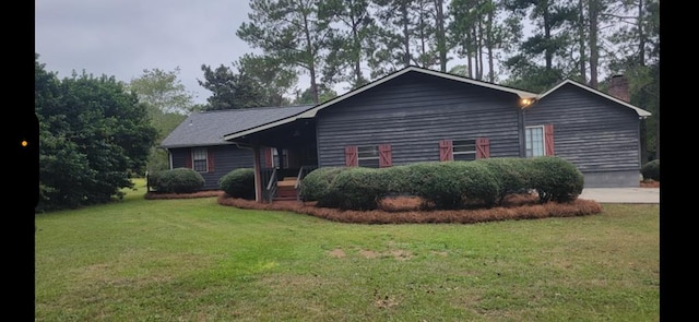 view of front of property with a chimney and a front lawn