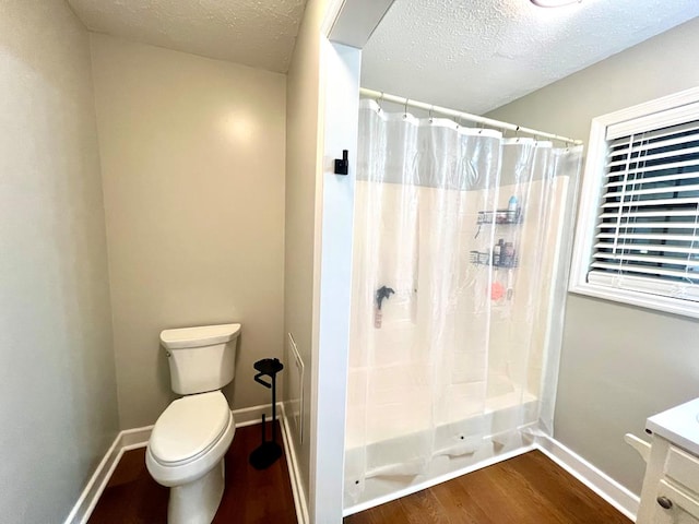 bathroom with a textured ceiling, toilet, wood finished floors, baseboards, and a shower with curtain