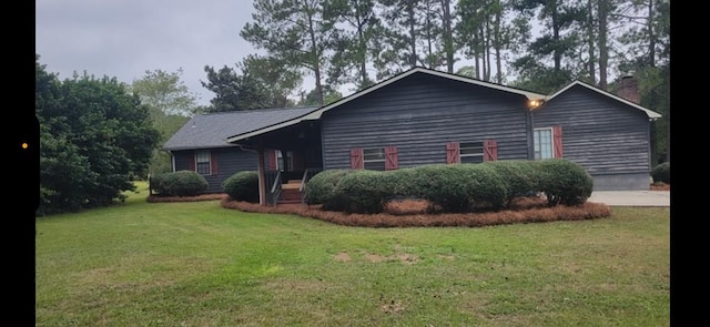 view of front of home featuring a chimney and a front lawn