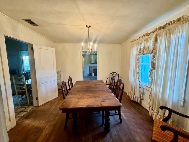 dining area with a chandelier, dark hardwood / wood-style floors, and crown molding