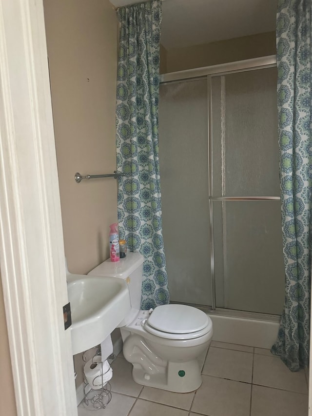 bathroom with tile patterned flooring, toilet, and walk in shower