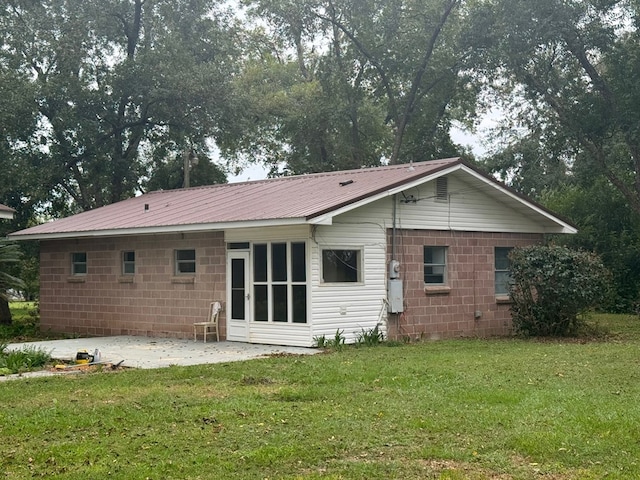 rear view of property with a lawn and a patio