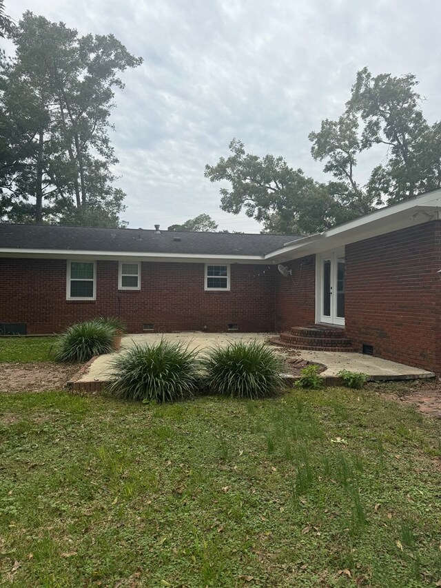 rear view of house with a patio area and a lawn