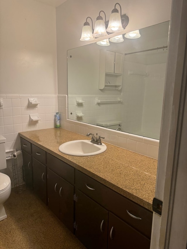 bathroom with vanity, tile walls, and toilet