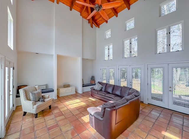 living room featuring beamed ceiling, a healthy amount of sunlight, french doors, and wood ceiling