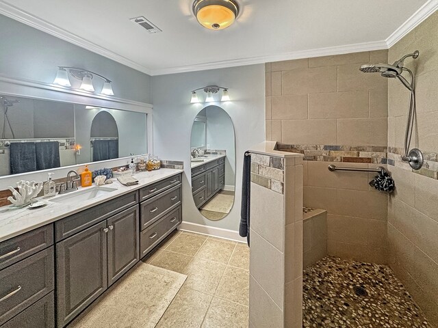 bathroom featuring ornamental molding, tile patterned flooring, vanity, and a tile shower