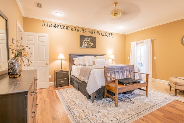 bedroom featuring light wood-type flooring, baseboards, visible vents, and ornamental molding