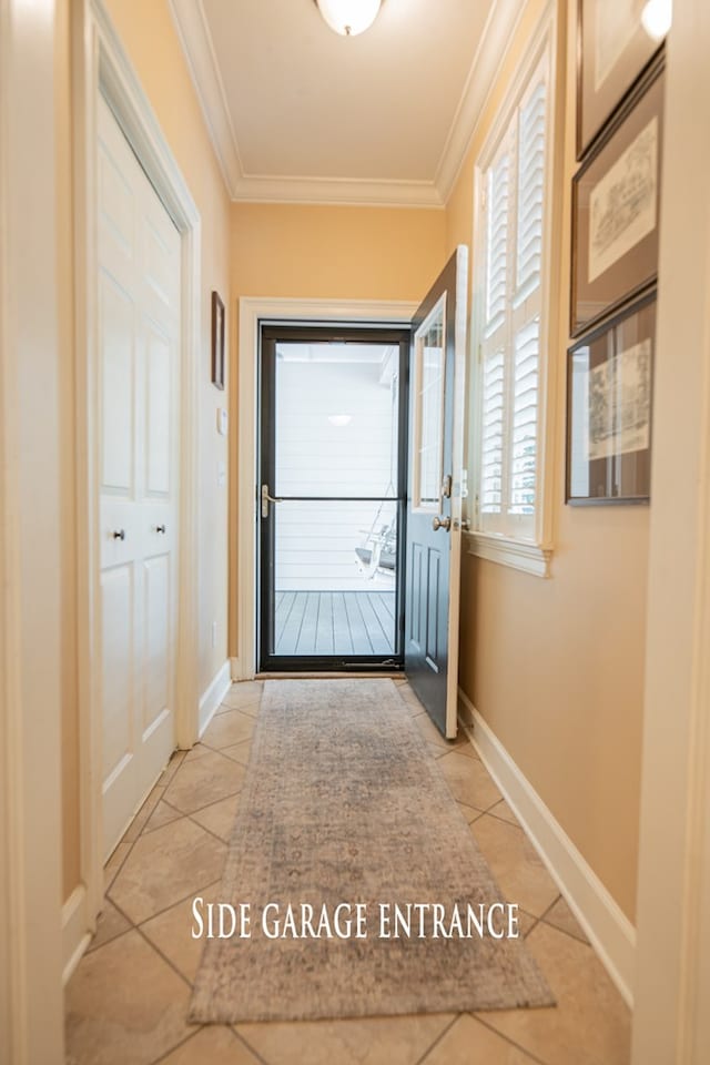 doorway to outside featuring ornamental molding, baseboards, and light tile patterned floors