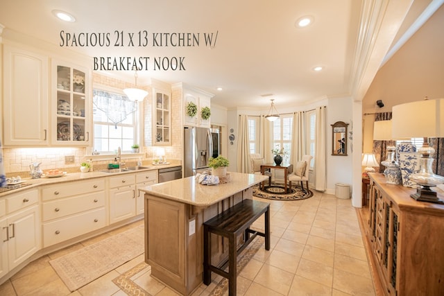 kitchen with appliances with stainless steel finishes, decorative light fixtures, a sink, and glass insert cabinets