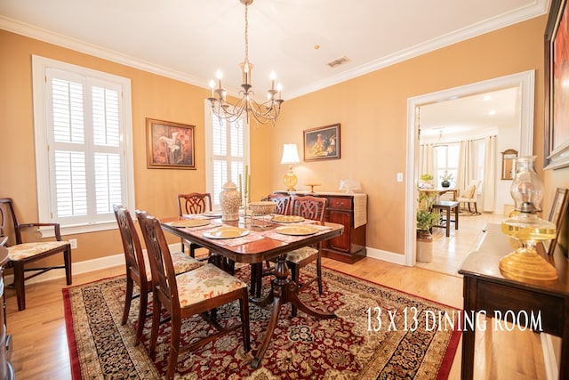 dining space with a healthy amount of sunlight, a notable chandelier, visible vents, and crown molding