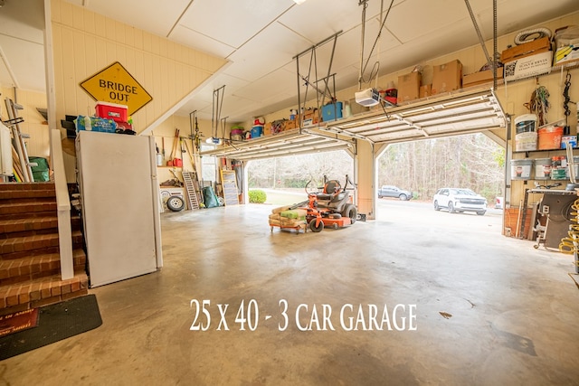 garage featuring freestanding refrigerator and a garage door opener