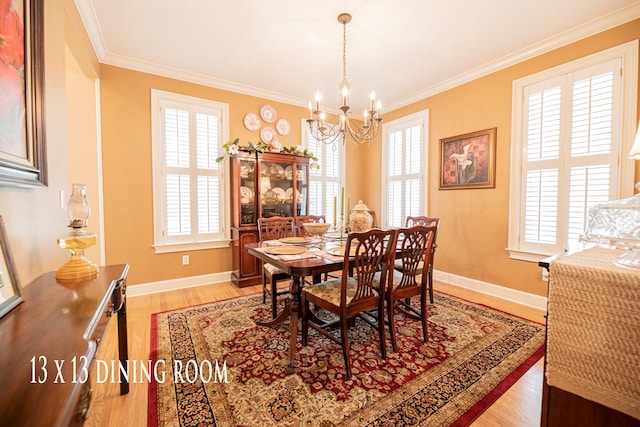 dining area with baseboards, ornamental molding, an inviting chandelier, and light wood-style floors