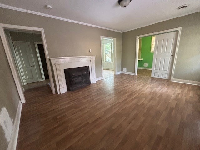 unfurnished living room featuring dark hardwood / wood-style flooring and crown molding