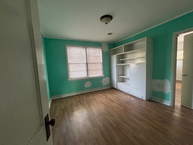 unfurnished bedroom with dark wood-type flooring