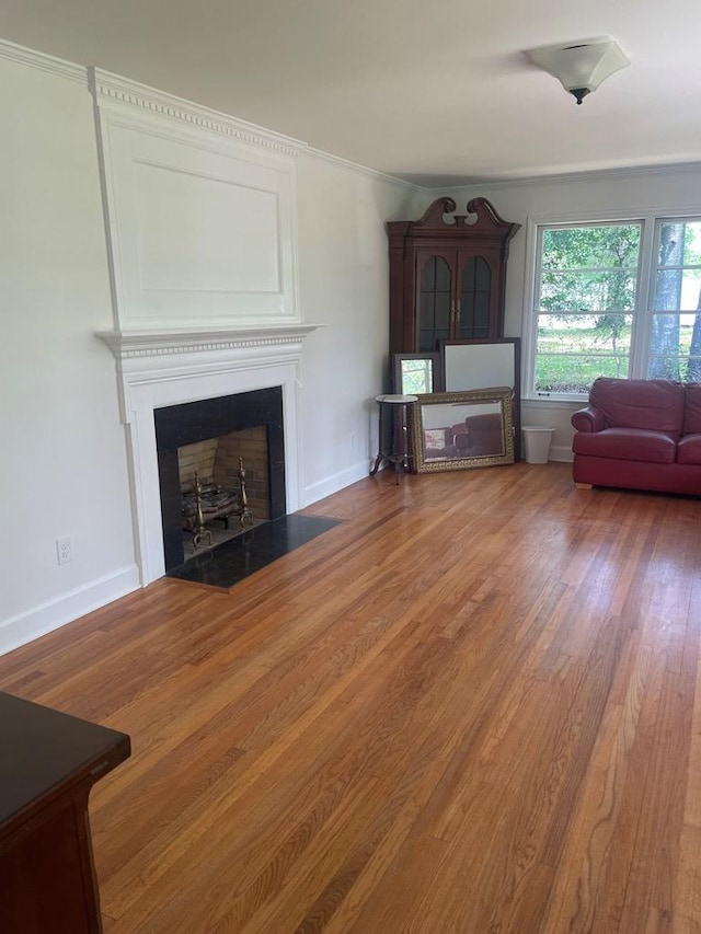 1202 Tallahassee Hwy, Bainbridge, GA 39819 - living room featuring a fireplace with flush hearth, wood finished floors, baseboards, and ornamental molding
