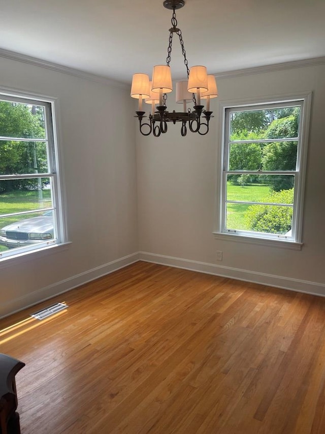 1202 Tallahassee Hwy, Bainbridge, GA 39819 - empty room featuring a chandelier, crown molding, light wood-type flooring, and baseboards