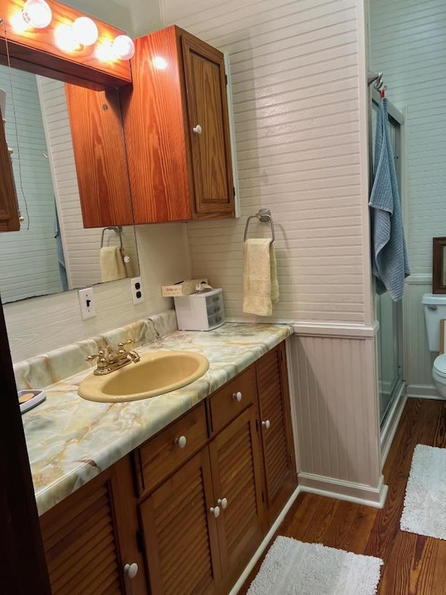 40 SW 5th Ave, Cairo, GA 39828 - bathroom with toilet, wood finished floors, a shower stall, vanity, and wooden walls