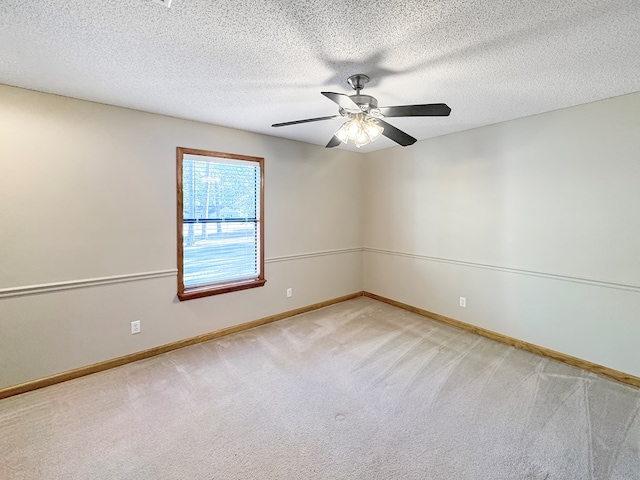 empty room with ceiling fan, a textured ceiling, and carpet floors