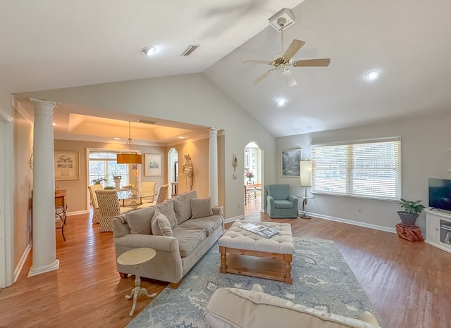 living room featuring ornate columns, a ceiling fan, vaulted ceiling, and light wood-style floors