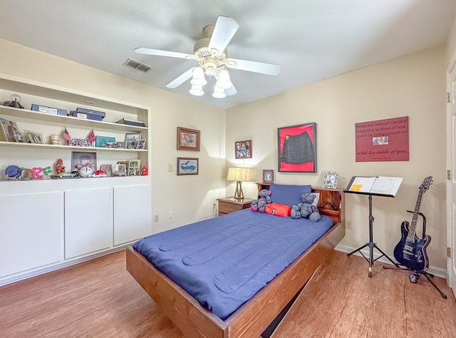 bedroom with visible vents, ceiling fan, and wood finished floors