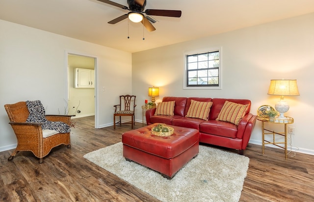 living room featuring ceiling fan and dark wood-type flooring