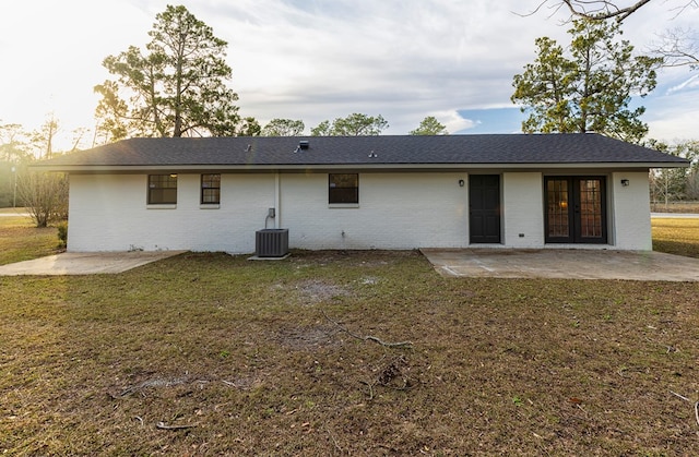 rear view of house featuring a lawn, central air condition unit, and a patio