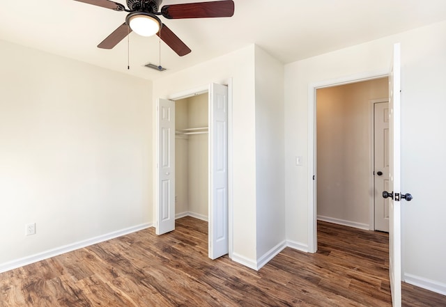 unfurnished bedroom with ceiling fan, dark hardwood / wood-style floors, and a closet