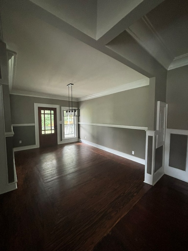 unfurnished living room with a chandelier, dark hardwood / wood-style flooring, and ornamental molding