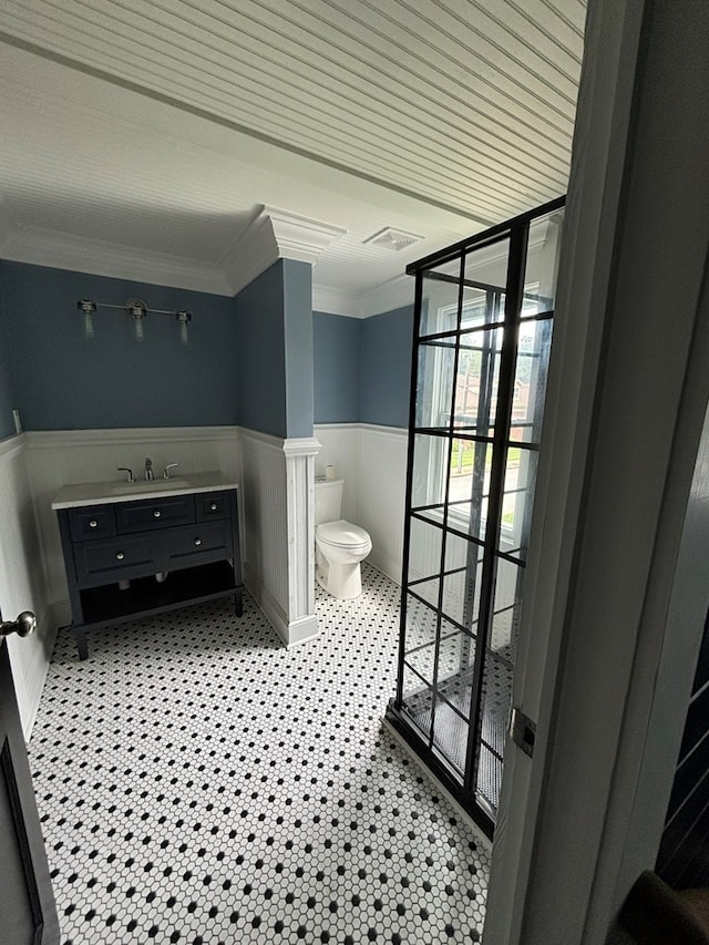 bathroom with vanity, ornamental molding, and toilet