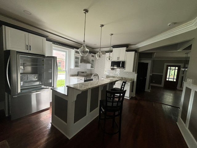 kitchen with light stone countertops, a center island with sink, white cabinets, and stainless steel appliances