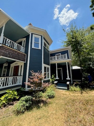 rear view of house featuring covered porch and a balcony