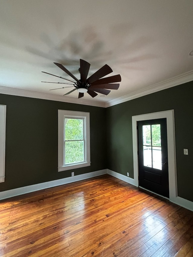 empty room with crown molding, light hardwood / wood-style flooring, ceiling fan, and a healthy amount of sunlight