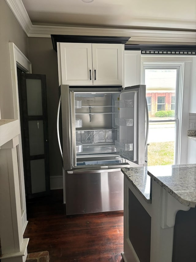 kitchen with light stone counters, ornamental molding, white cabinets, dark hardwood / wood-style floors, and stainless steel refrigerator