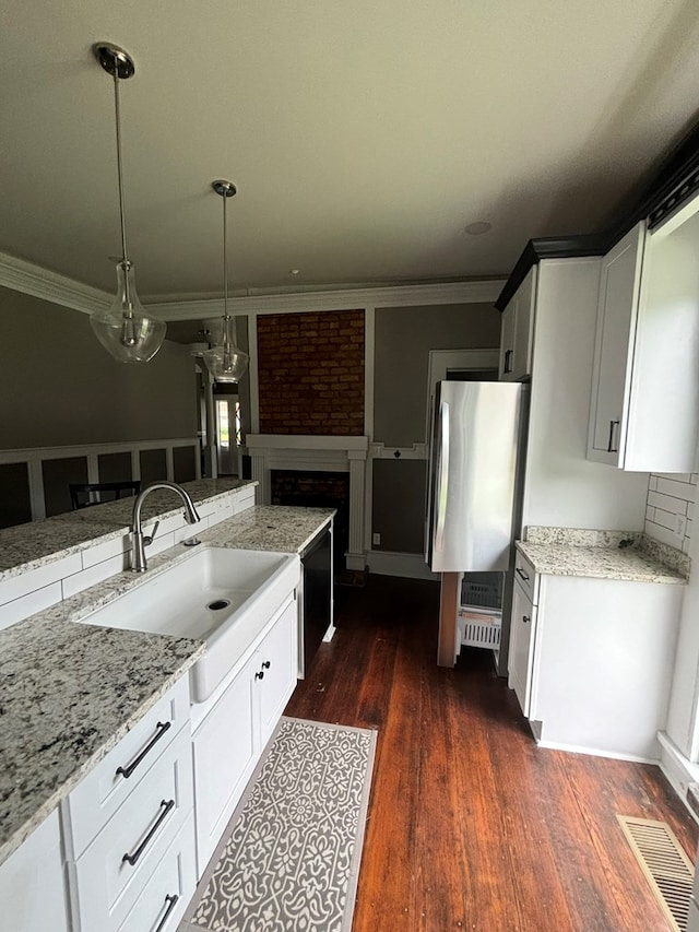 kitchen featuring decorative light fixtures, light stone countertops, white cabinetry, and a fireplace