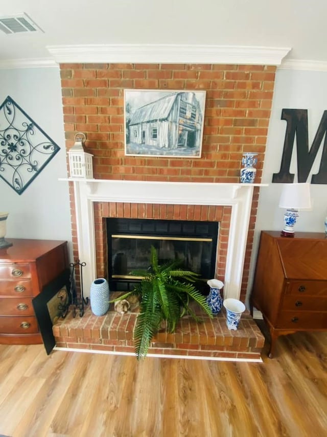 interior details featuring hardwood / wood-style floors, crown molding, and a fireplace