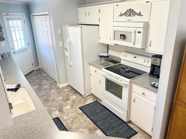 kitchen with backsplash, white appliances, crown molding, sink, and white cabinetry