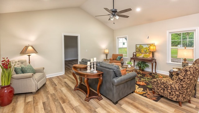 living room featuring ceiling fan, high vaulted ceiling, and light wood-type flooring