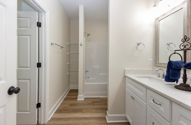 bathroom with shower / bathing tub combination, hardwood / wood-style floors, and vanity