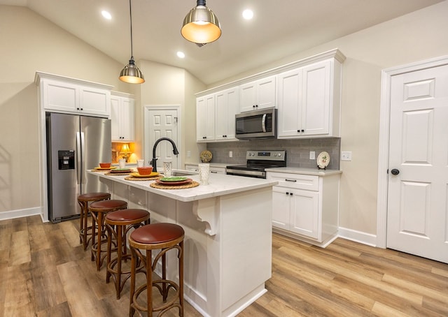 kitchen with white cabinetry, sink, lofted ceiling, and stainless steel appliances