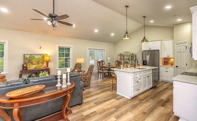 kitchen featuring ceiling fan, light stone counters, pendant lighting, white cabinets, and light wood-type flooring