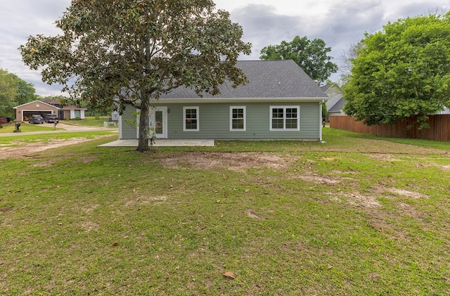 back of property with a yard and a patio